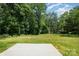 Lot with a concrete pad surrounded by grass and trees underneath a blue sky at 157 Fraley Rd, Gastonia, NC 28052