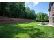 Large, well-maintained backyard with retaining wall and lush greenery, featuring patio set at 16016 Reynolds Dr, Fort Mill, SC 29707