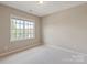 Bright bedroom featuring carpet flooring, a window for natural light, and ample wall space at 16016 Reynolds Dr, Fort Mill, SC 29707