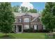 Two-story brick home with meticulously maintained lawn, mature trees, and classic architectural details at 16016 Reynolds Dr, Fort Mill, SC 29707
