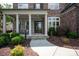 Inviting front porch with stone accents, white pillars, and manicured landscaping at 16016 Reynolds Dr, Fort Mill, SC 29707