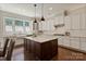 Bright kitchen with stainless steel appliances, farmhouse sink, and dark wood island with granite countertops at 16016 Reynolds Dr, Fort Mill, SC 29707