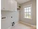 Laundry room with tile flooring, overhead cabinets, and a window for natural light at 16016 Reynolds Dr, Fort Mill, SC 29707