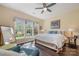 A bedroom with hardwood floors, a ceiling fan, and large windows, providing natural light and ventilation at 16260 Raven Crest Dr, Indian Land, SC 29707