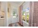 Bright entryway features a charming rug, window with patterned curtains, and a glass paneled door at 16260 Raven Crest Dr, Indian Land, SC 29707