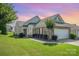Charming brick home featuring manicured lawn, lush landscaping, and attached two-car garage at 16260 Raven Crest Dr, Indian Land, SC 29707