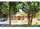 Quaint brick house framed by trees, featuring a welcoming front porch at 169 Smith Clemmer Rd, Mount Holly, NC 28120
