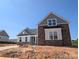 New construction home exhibits stone and green siding exterior with a gray roof, awaiting landscaping at 2085 Fordhill St, Rock Hill, SC 29732