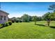 Well-manicured backyard with grass, trees, and landscaping at 2117 Copperplate Rd, Charlotte, NC 28262