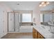 This bathroom offers double vanity, glass shower, soaking tub, and window at 2117 Copperplate Rd, Charlotte, NC 28262