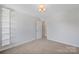 Bedroom featuring overhead lighting, a window, carpet, and white shelving unit at 2117 Copperplate Rd, Charlotte, NC 28262
