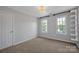 Bedroom features carpet, two windows, overhead lighting, and white shelving at 2117 Copperplate Rd, Charlotte, NC 28262