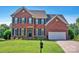 Traditional two-story brick home featuring a well-manicured lawn and a two-car garage at 2117 Copperplate Rd, Charlotte, NC 28262