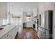 Open concept kitchen with white cabinets, hardwood floors, and stainless steel appliances at 2117 Copperplate Rd, Charlotte, NC 28262