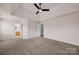 Spacious main bedroom featuring tray ceilings, fan, carpet, and ensuite bath at 2117 Copperplate Rd, Charlotte, NC 28262