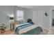 Cozy bedroom with light blue walls, a window with white curtains, and closet with bi-fold doors at 2926 Royal Fern Ln, Charlotte, NC 28215