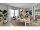 Bright dining room with seating for six, tile floors, plants, and sightlines to other rooms at 2926 Royal Fern Ln, Charlotte, NC 28215