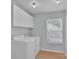 Bright laundry room features white cabinets, a window, and a washer and dryer set at 2926 Royal Fern Ln, Charlotte, NC 28215