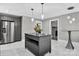 An open-concept kitchen with stainless steel appliances, gray cabinets and a kitchen island at 3127 N Center St, Hickory, NC 28601