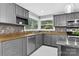 Well-lit kitchen with stainless steel appliances, stone countertops, and tile backsplash at 3127 N Center St, Hickory, NC 28601