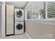 Bright laundry room with stacked washer/dryer and storage cabinet by a window at 3127 N Center St, Hickory, NC 28601