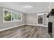 Bright living room featuring a stone fireplace, hardwood floors, large windows and a doorway to another room at 3127 N Center St, Hickory, NC 28601