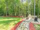 Expansive backyard showcasing a fire pit, stone patio, and lush green lawn at 3227 Cape Fox Ct, Denver, NC 28037