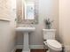 This bathroom features a pedestal sink, a decorative mirror, and tiled flooring at 3227 Cape Fox Ct, Denver, NC 28037