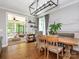 Dining room with hardwood floors and modern chandelier, and an open door to a screened-in porch at 3227 Cape Fox Ct, Denver, NC 28037