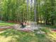 Landscaped backyard area featuring a stone fire pit with Adirondack chairs and seating at 3227 Cape Fox Ct, Denver, NC 28037