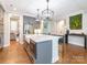 The bright kitchen showcases a large island with seating, stainless appliances, and modern pendant lighting at 3227 Cape Fox Ct, Denver, NC 28037