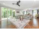 Bright living room featuring hardwood floors, modern ceiling fan, and an oversized gray sectional sofa at 3227 Cape Fox Ct, Denver, NC 28037