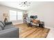 Office space with wood-look floors, a gray sofa, modern desk and lighting and an open shelving unit at 3227 Cape Fox Ct, Denver, NC 28037