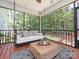 Relaxing screened-in porch with a daybed swing, comfortable seating, and wooded views at 3227 Cape Fox Ct, Denver, NC 28037