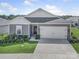Single-story home featuring a two-car garage, and well-maintained lawn and landscaping at 3317 Black Cherry Dr, Monroe, NC 28110