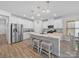 Modern white kitchen with stainless steel appliances, granite countertops, and a breakfast bar at 3317 Black Cherry Dr, Monroe, NC 28110