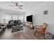 Cozy living room with wood floors, ceiling fan, comfortable furniture, and a large screen TV at 3317 Black Cherry Dr, Monroe, NC 28110