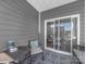 Covered patio with wicker seating, table, and a view through the sliding glass doors at 3317 Black Cherry Dr, Monroe, NC 28110