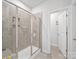 Modern walk-in shower with glass door, gray tile, built-in niches, and sleek hardware at 3317 Black Cherry Dr, Monroe, NC 28110