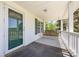 Inviting covered front porch features a swing, railing, and a door with glass panels at 38367 Loblolly Ln, New London, NC 28127
