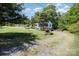 Exterior view showcasing the home with a ramp, foliage, shed, and partial driveway at 38367 Loblolly Ln, New London, NC 28127