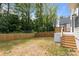 View of backyard featuring wood fence and modern home with white brick foundation at 3937 Plainview Rd, Charlotte, NC 28208