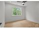 Bright bedroom with natural light, hardwood floors, a ceiling fan and a serene view from the window at 3937 Plainview Rd, Charlotte, NC 28208
