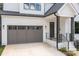 A modern home featuring a gray garage door, black trim windows, and a welcoming front entrance at 3937 Plainview Rd, Charlotte, NC 28208
