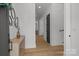 Bright hallway with hardwood floors, white walls, and modern black door accents at 3937 Plainview Rd, Charlotte, NC 28208