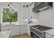 Bright kitchen with stainless steel appliances, quartz countertops, and large window overlooking trees at 3937 Plainview Rd, Charlotte, NC 28208