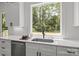 Kitchen has a large window above the sink with stainless steel appliances and white quartz countertops at 3937 Plainview Rd, Charlotte, NC 28208