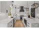 Well-lit kitchen boasts white countertops and cabinets, a center island, and stainless steel appliances at 3937 Plainview Rd, Charlotte, NC 28208