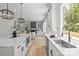 Open kitchen into living room with stainless steel appliances, a large island, and modern cube pendant lights at 3937 Plainview Rd, Charlotte, NC 28208