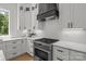 Kitchen has a stainless steel stove with sleek white cabinetry and quartz countertops at 3937 Plainview Rd, Charlotte, NC 28208